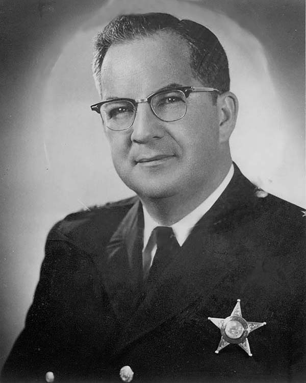 [Image: James Conlisk Jr., middle-aged, in glasses, and in police uniform.]