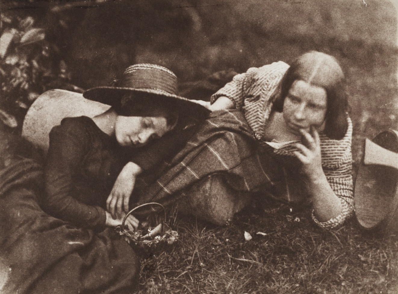 [Image: Two Scottish sisters in their teens or thereabouts, relaxing on an Edinburgh lawn, one in wide-brimmed hat and black dress, the other in tartan skirt and ticked blouse.]