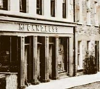[Image: McCandless shop-front on a street around the turn of the previous century.]